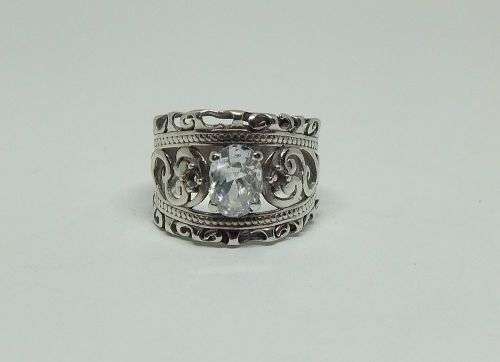 A CHARMING SOLID STERLING SILVER RING SET WITH A FACETED CLEAR STONE !! LOTS OF CURVEY DETAIL !!