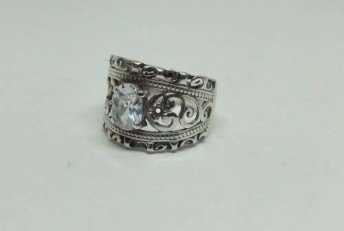 A CHARMING SOLID STERLING SILVER RING SET WITH A FACETED CLEAR STONE !! LOTS OF CURVEY DETAIL !!