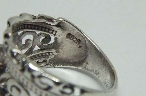 A CHARMING SOLID STERLING SILVER RING SET WITH A FACETED CLEAR STONE !! LOTS OF CURVEY DETAIL !!