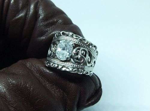 A CHARMING SOLID STERLING SILVER RING SET WITH A FACETED CLEAR STONE !! LOTS OF CURVEY DETAIL !!