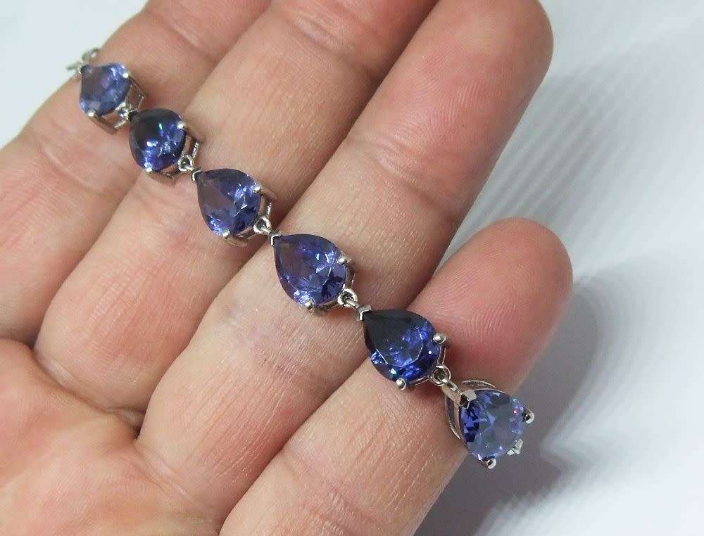 A MAGNIFICENT DESIGNER STERLING SILVER BRACELET SET WITH FACETED BLUEISH PEAR SHAPED STONES !! WOW !