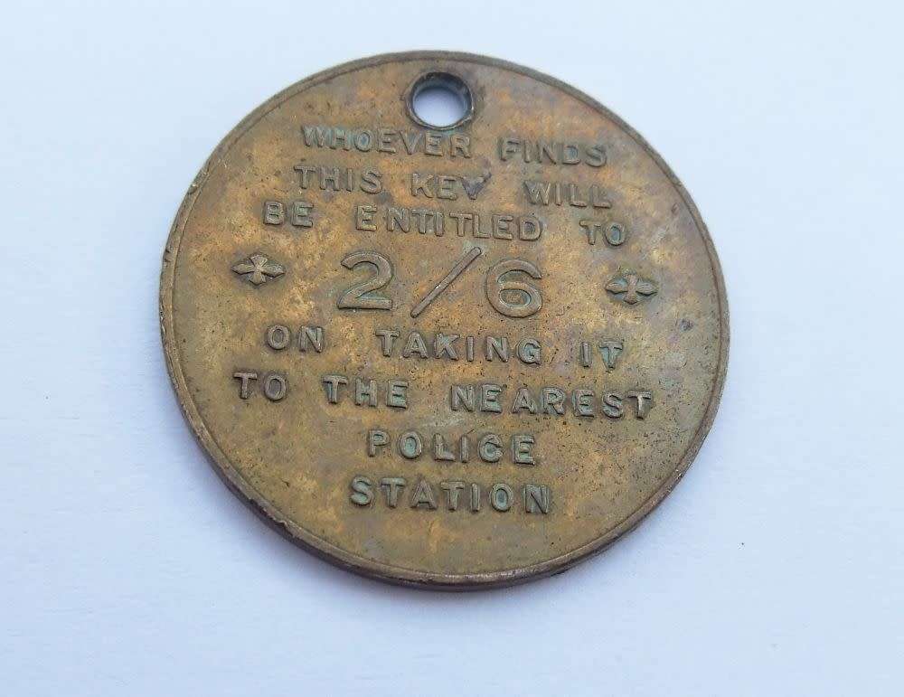 A vintage South African Post Office lost key token entitling the finder to 2 shillings and 6 pence