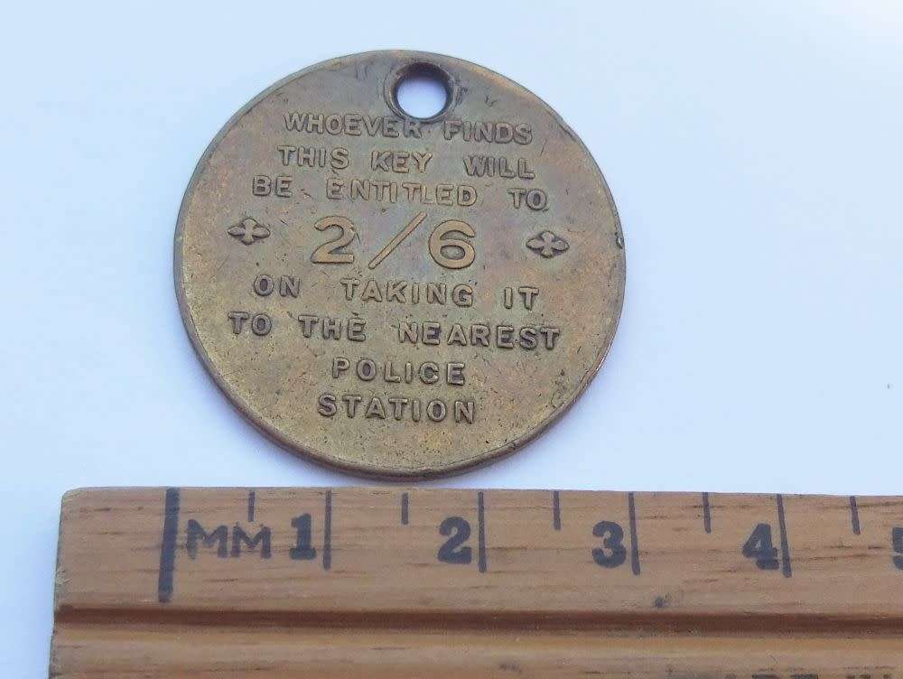 A vintage South African Post Office lost key token entitling the finder to 2 shillings and 6 pence