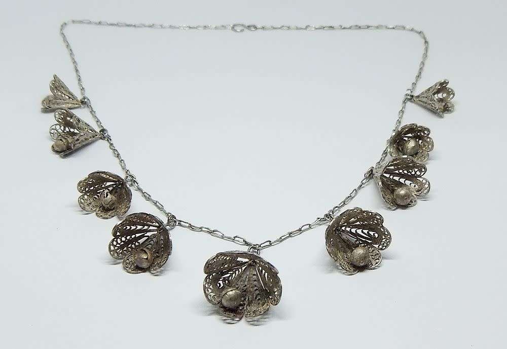 A vintage sterling silver necklace with silver filigree bell attachments
