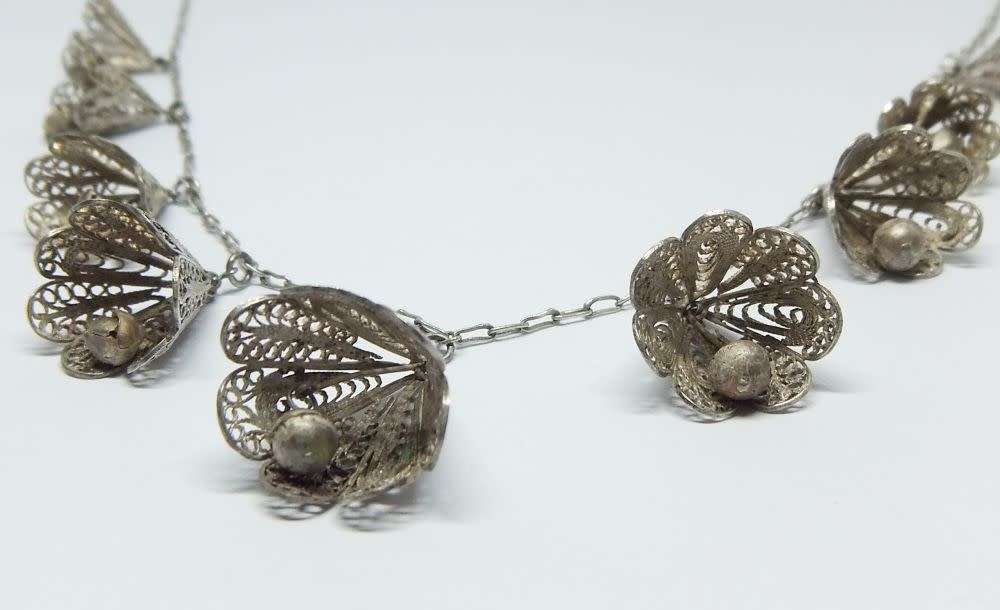 A vintage sterling silver necklace with silver filigree bell attachments