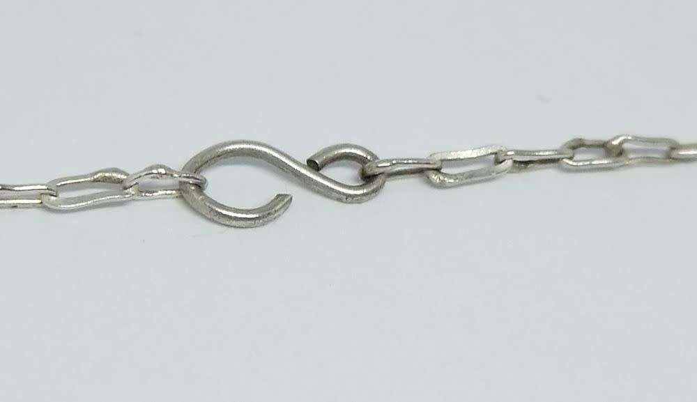 A vintage sterling silver necklace with silver filigree bell attachments