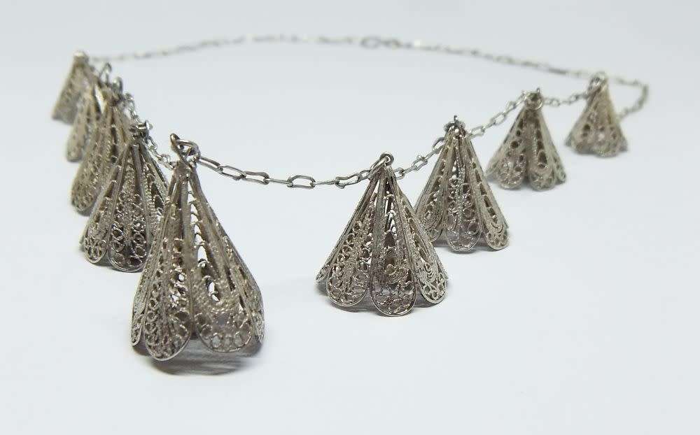A vintage sterling silver necklace with silver filigree bell attachments