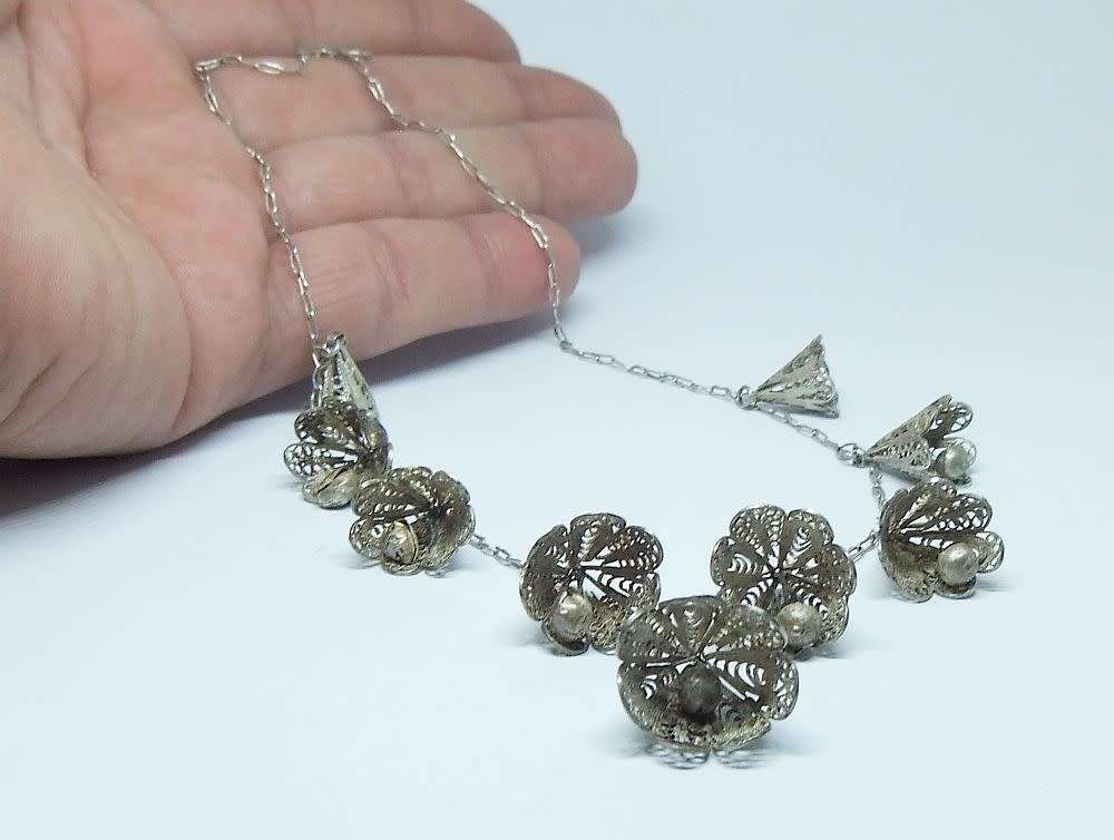 A vintage sterling silver necklace with silver filigree bell attachments