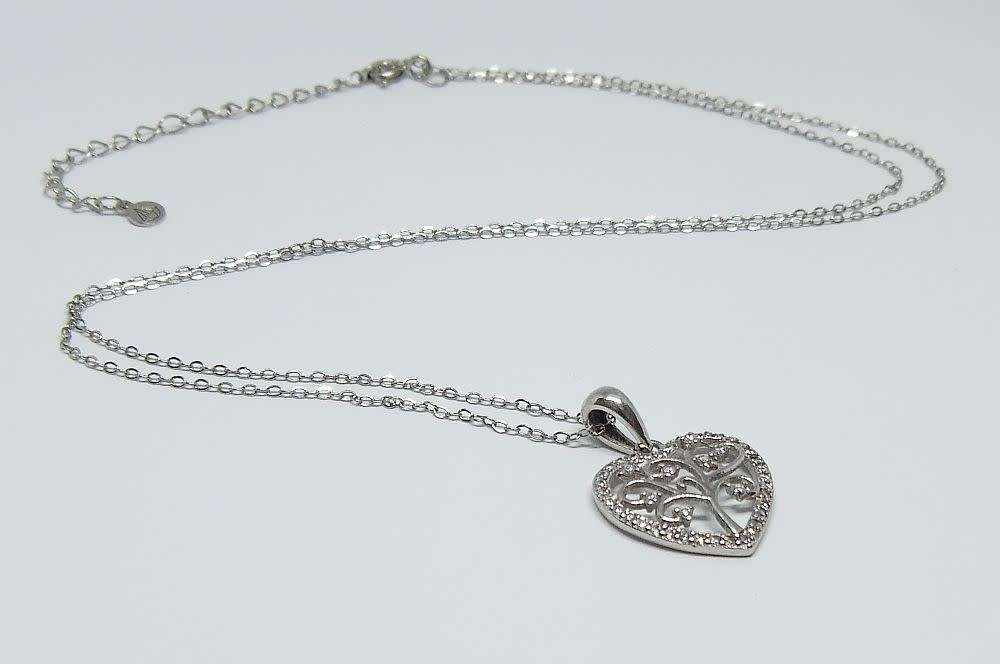 A genuine sterling silver necklace and heart pendant containing the tree of life with clear insets