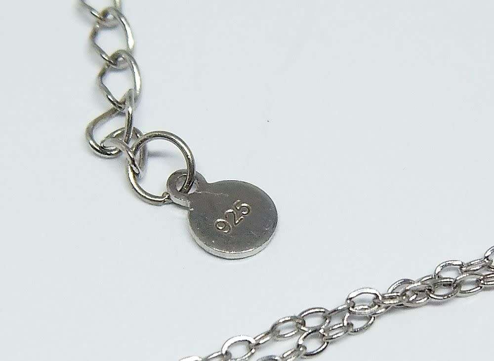 A genuine sterling silver necklace and heart pendant containing the tree of life with clear insets