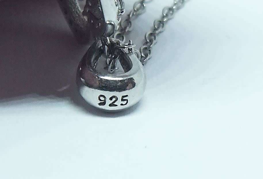 A genuine sterling silver necklace and heart pendant containing the tree of life with clear insets