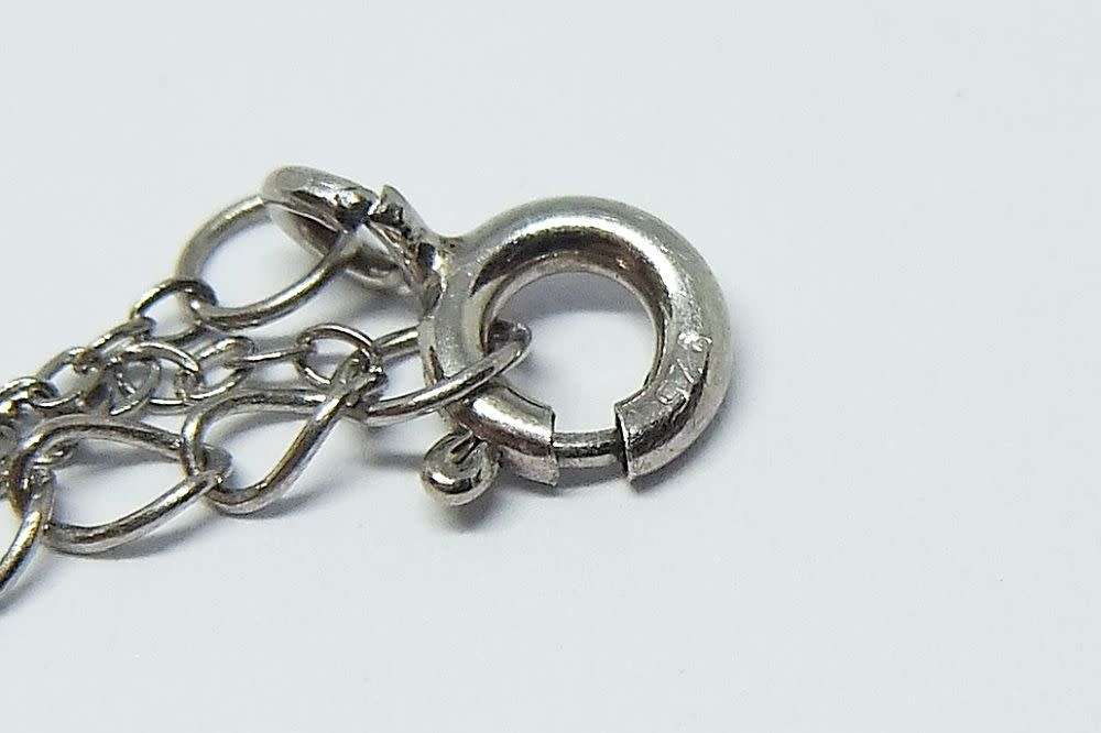 A genuine sterling silver necklace and heart pendant containing the tree of life with clear insets