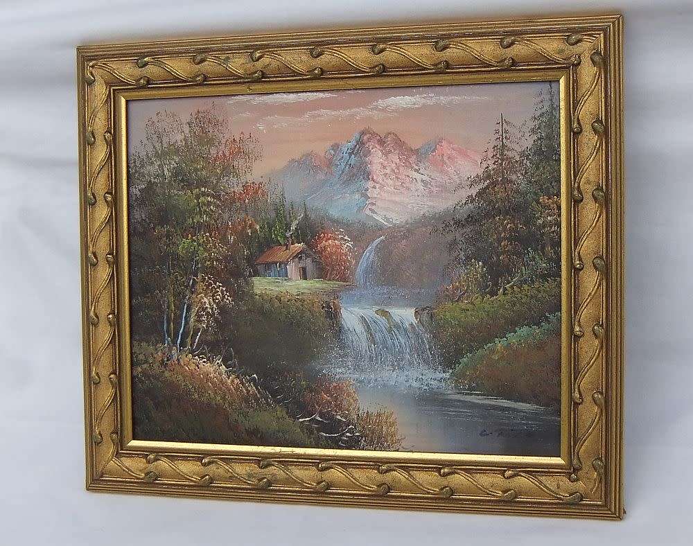 A signed oil painting depicting a forrest landscape with cottage and waterfalls