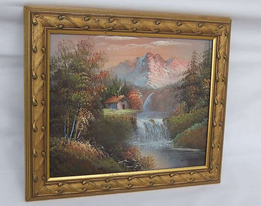A signed oil painting depicting a forrest landscape with cottage and waterfalls