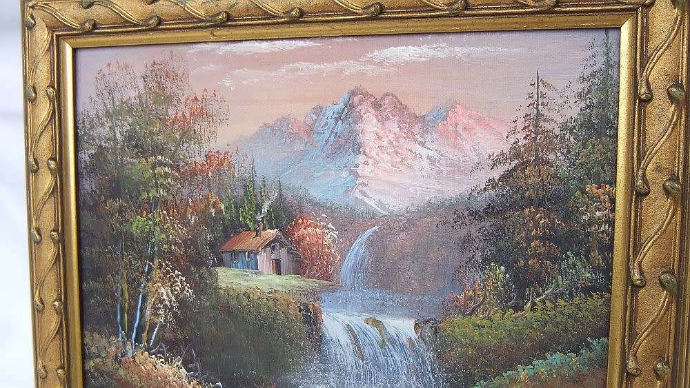 A signed oil painting depicting a forrest landscape with cottage and waterfalls