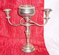 An old candle holder with posy vase