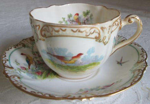 1891-1893  GEORGE JONES & SON,  CUP AND SAUCER, HAND TOUCHED OVER TRANSFER BIRD DESIGN WITH GILDING