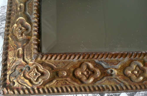 ANTIQUE, RECTANGULAR BEVELED MIRROR SET WITHIN A DECORATIVE PRESSED METAL FRAME