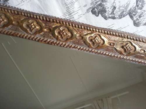 ANTIQUE, RECTANGULAR BEVELED MIRROR SET WITHIN A DECORATIVE PRESSED METAL FRAME