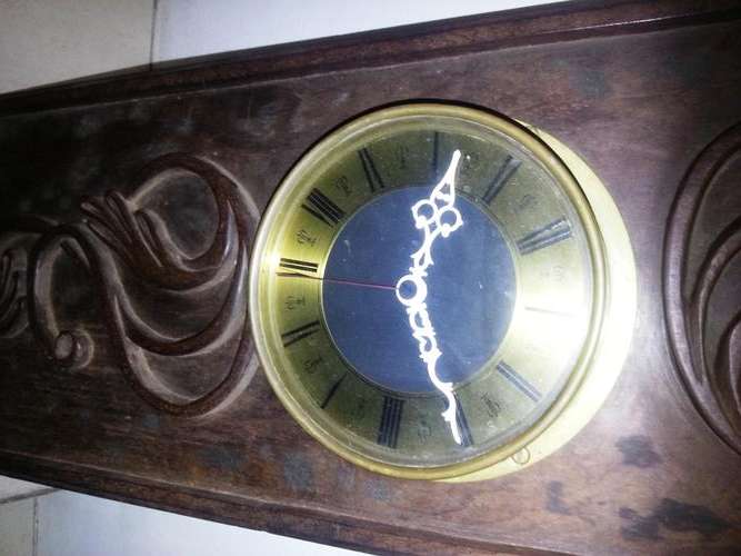 LARGE BRASS CLOCK SET INSIDE WOODEN CARVING