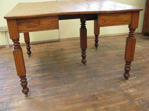 COLONIAL OAK TABLE WITH 5 LEGS AND ON ORIGINAL CASTORS