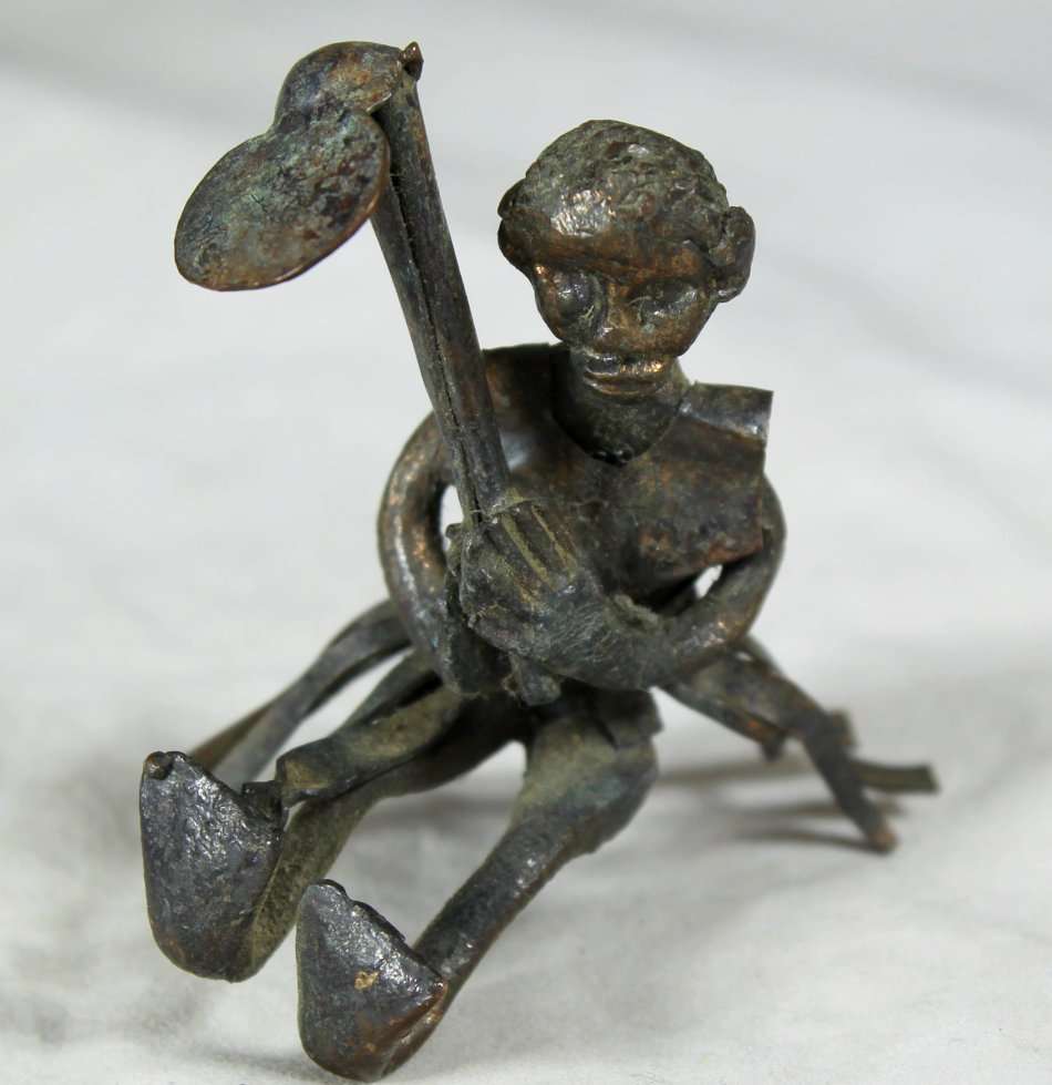 Miniature metal man with hoe
