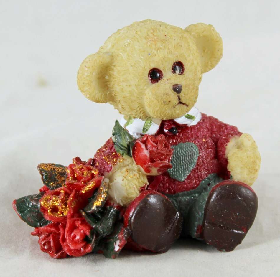 Small bear holding bunch of roses