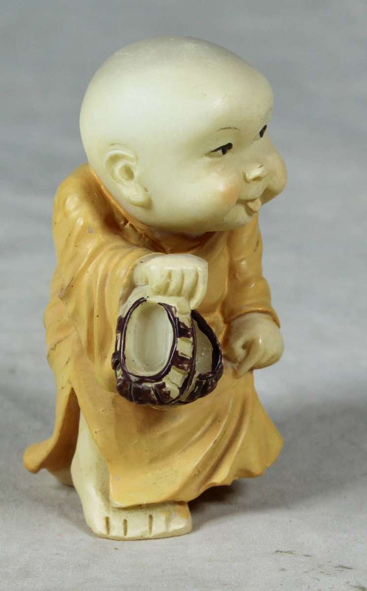 Baby Buddha - Carrying his Shoes and Sticking his Tongue Out