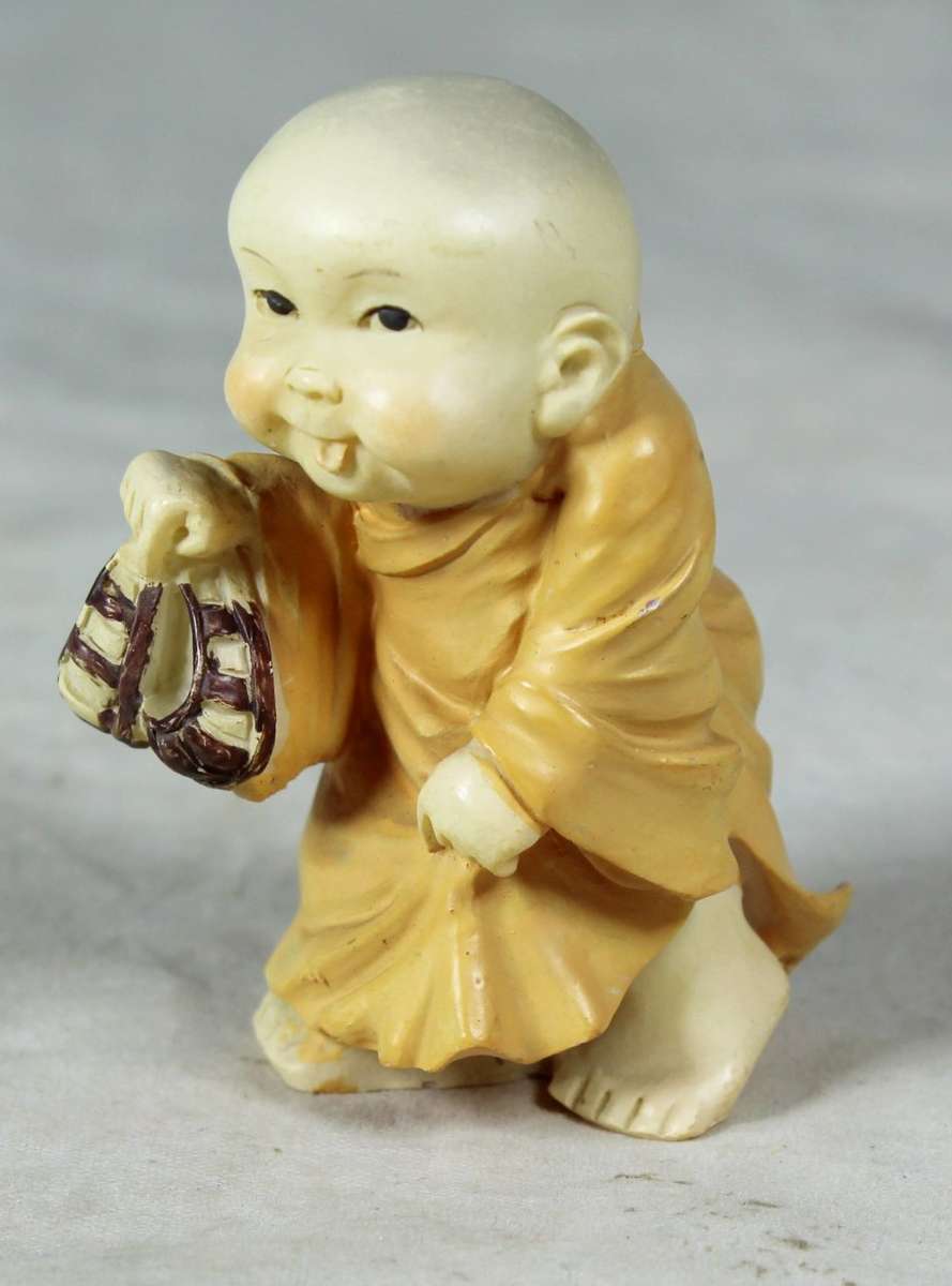 Baby Buddha - Carrying his Shoes and Sticking his Tongue Out