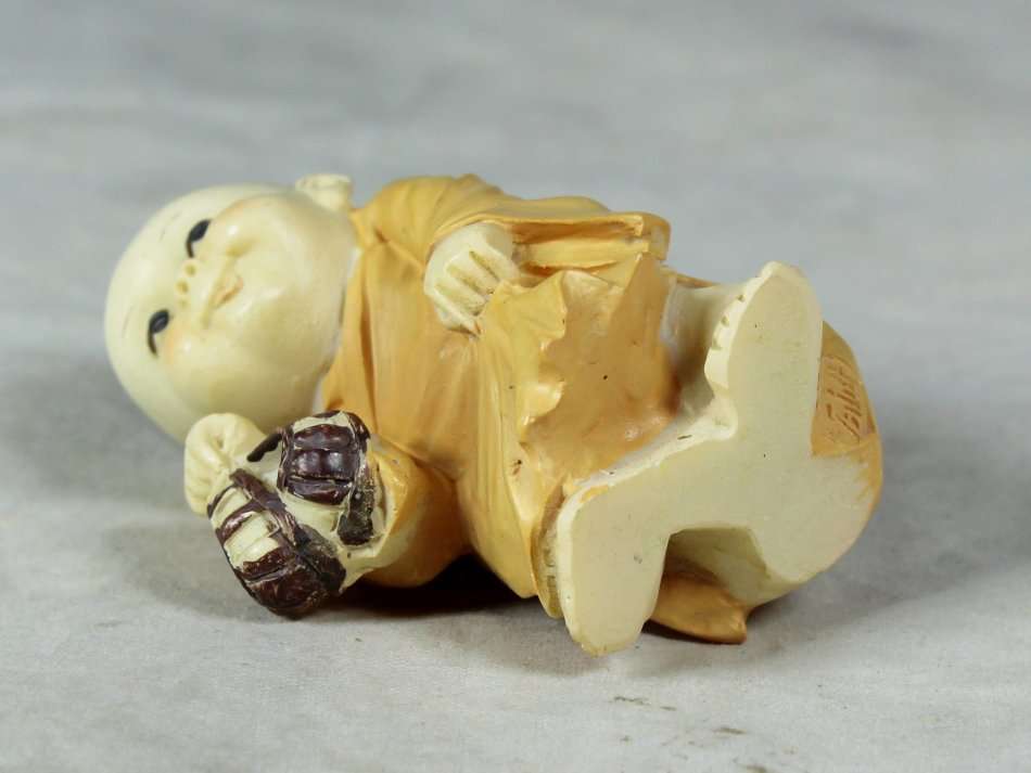 Baby Buddha - Carrying his Shoes and Sticking his Tongue Out