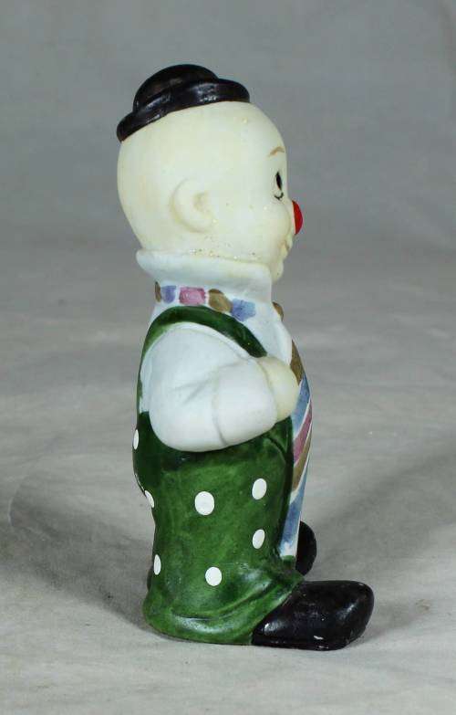 Ceramic clown in a green polka dot jump suit and tie