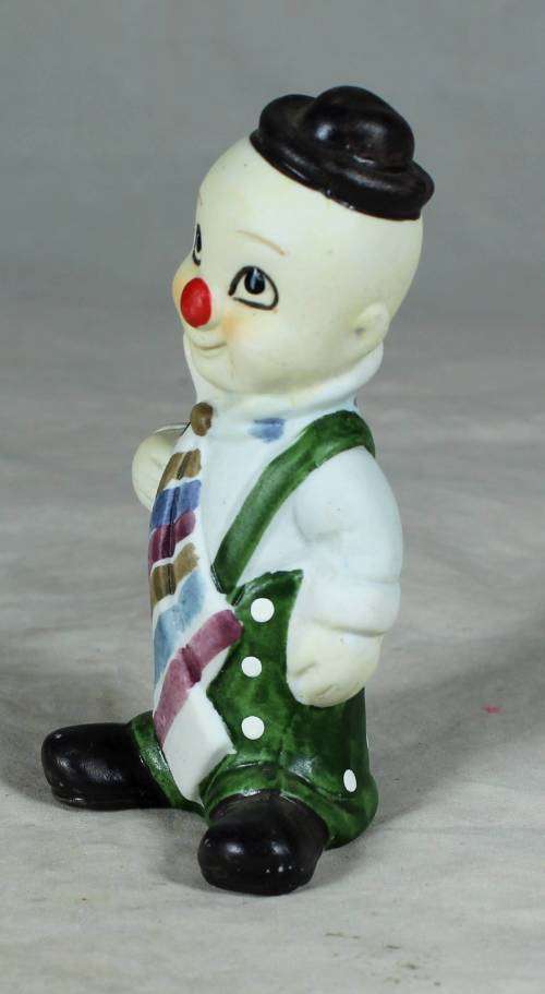 Ceramic clown in a green polka dot jump suit and tie