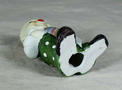 Ceramic clown in a green polka dot jump suit and tie