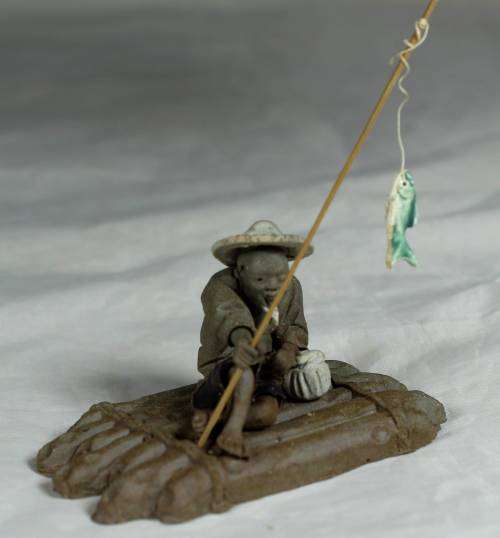 Mud Men - Man on a raft with a fish