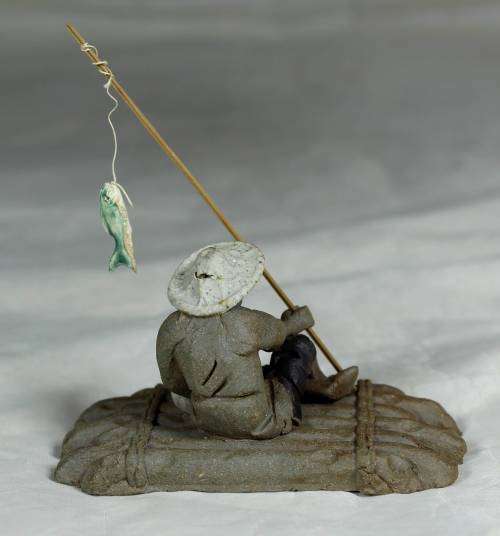 Mud Men - Man on a raft with a fish