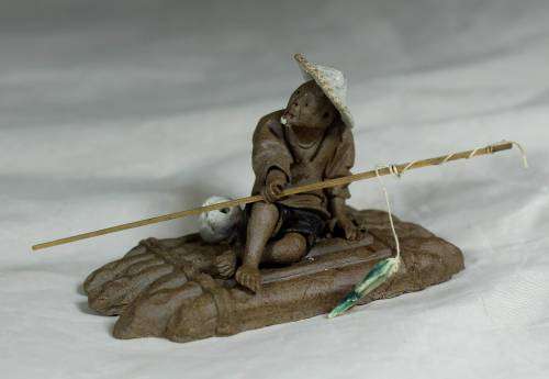 Mud Men - Man on a raft with a fish