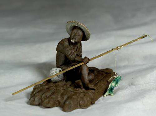 Mud Men - Man on a raft with a fish