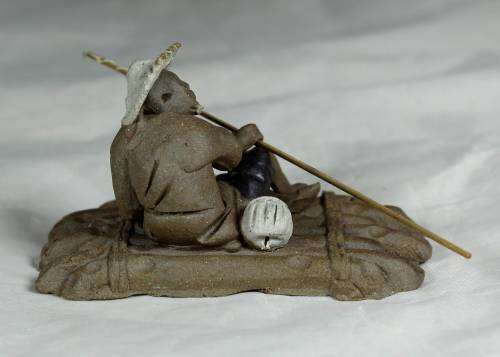 Mud Men - Man on a raft with a fish