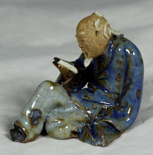 Mud Men - Seated man reading