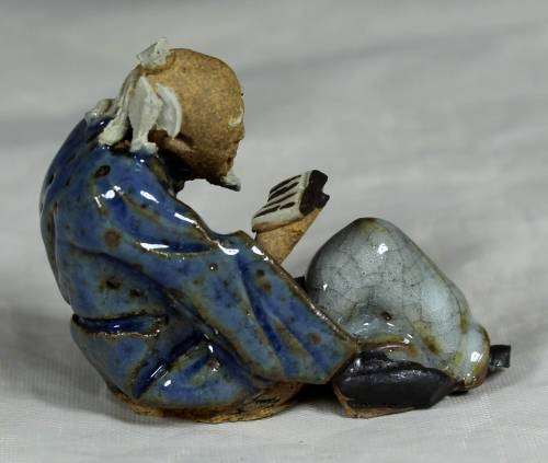 Mud Men - Seated man reading