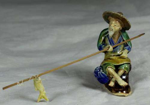 Mud Men - Old man seated & fishing in a brown hat