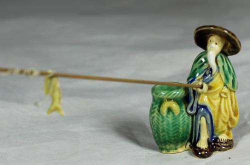 Mud Men - Old man fishing next to a large green barrel