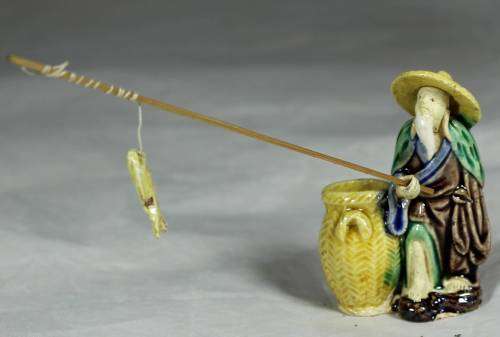 Mud Men - Old man fishing next to a large brown barrel