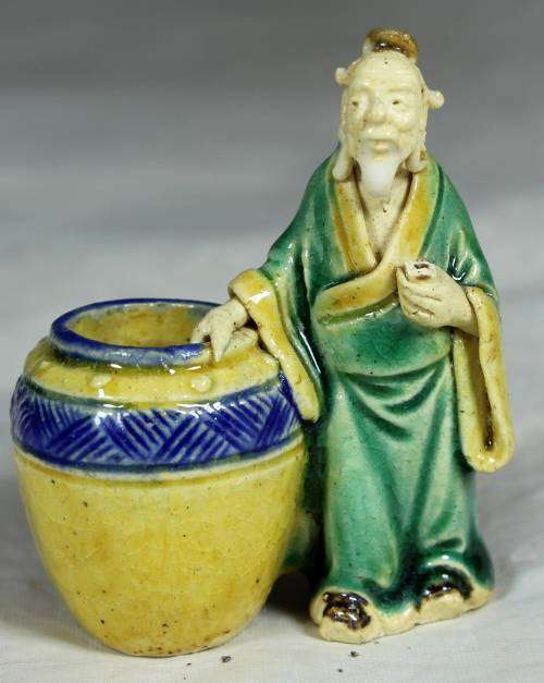 Mud men - old man holding onto a large barrel