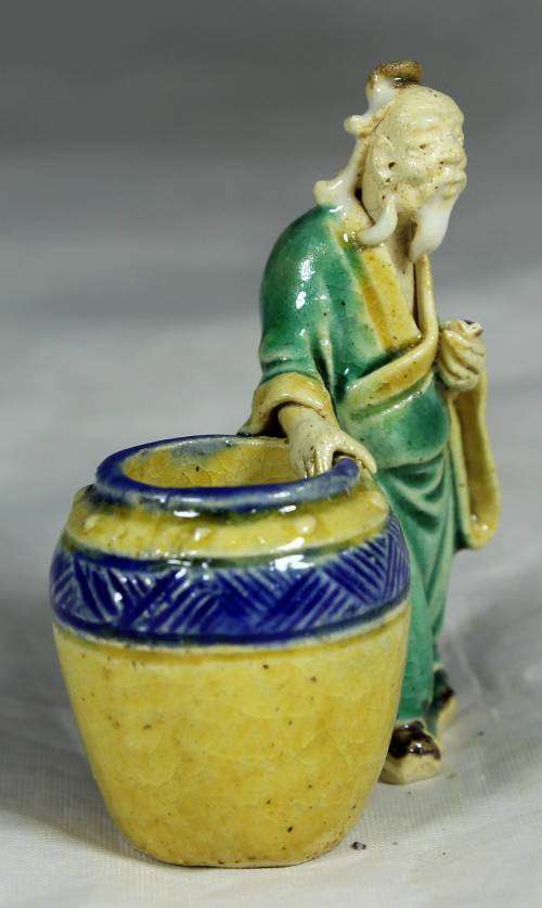 Mud men - old man holding onto a large barrel