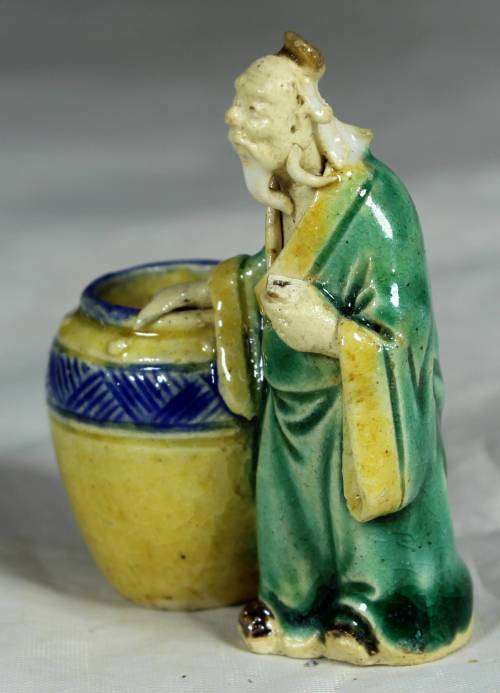 Mud men - old man holding onto a large barrel