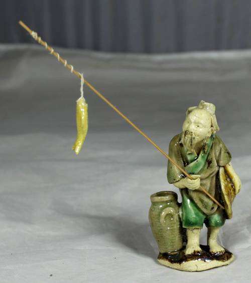 Mud Men - Old man holding a fish and hat