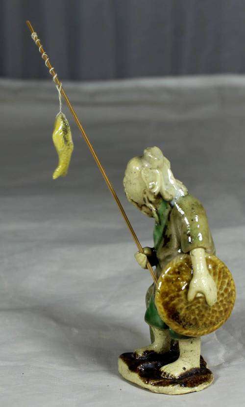 Mud Men - Old man holding a fish and hat