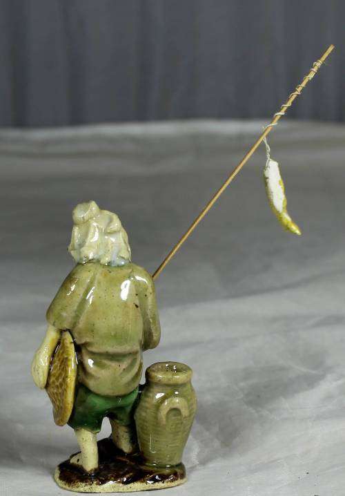 Mud Men - Old man holding a fish and hat