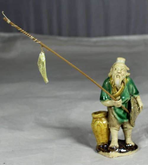 Mud Men - Old man holding a fish and hat